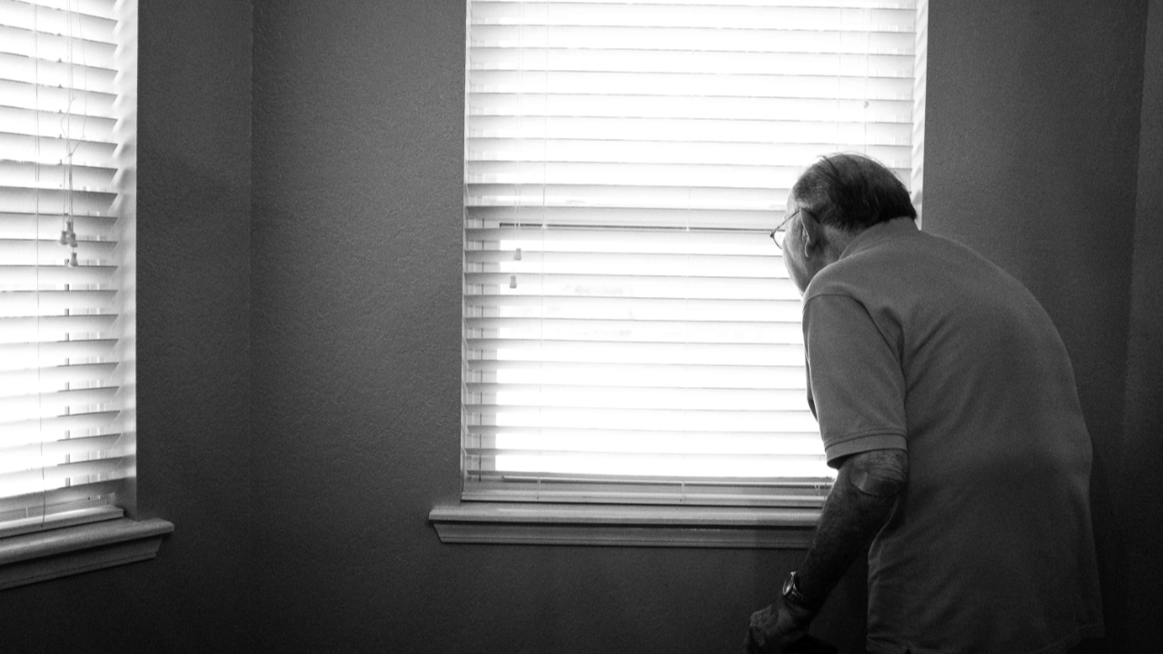 Man standing inside white painted room by Alex Boyd